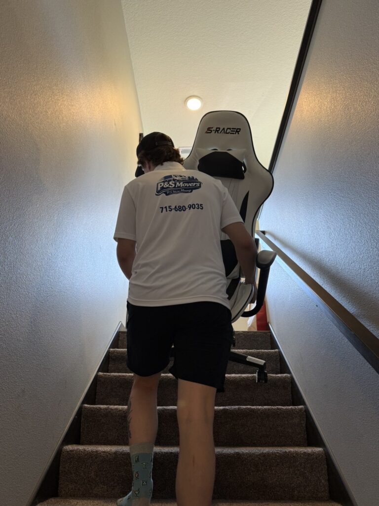 PS Movers moving a chair up the stairs